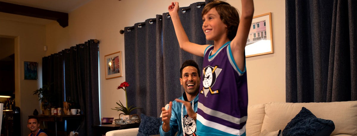 A young hockey fan cheering in an Anaheim Ducks youth hockey tank at home