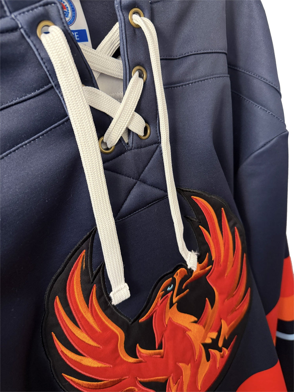 Hockey-lace neckline and embroidered crest on a lace hoodie