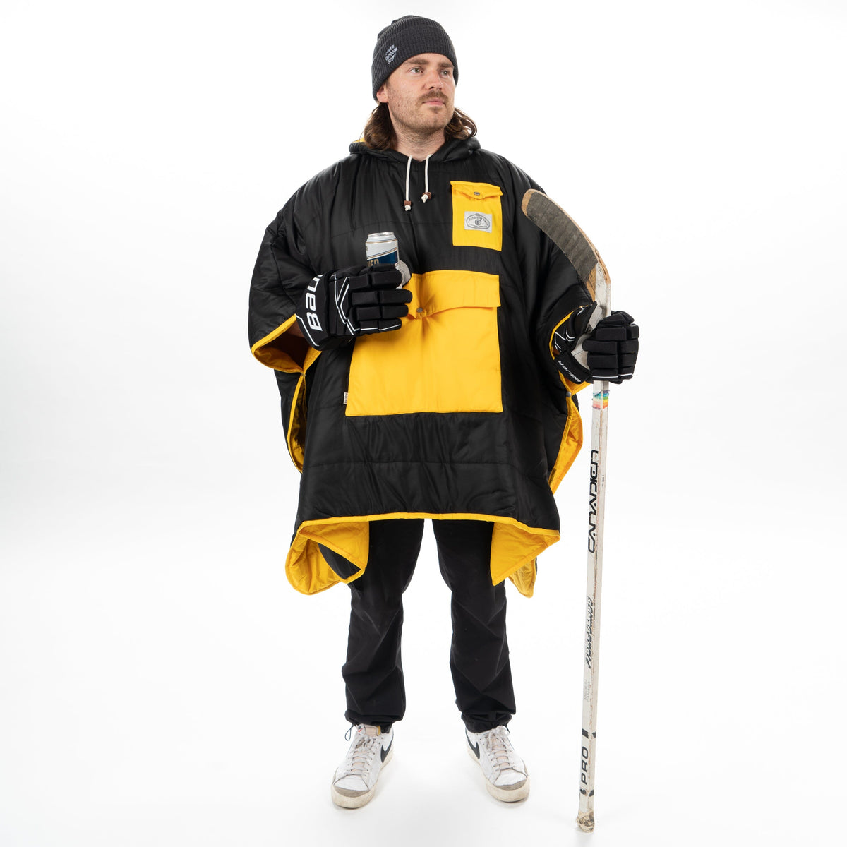 Reversible Boston Bruins hockey poncho worn with a hockey stick