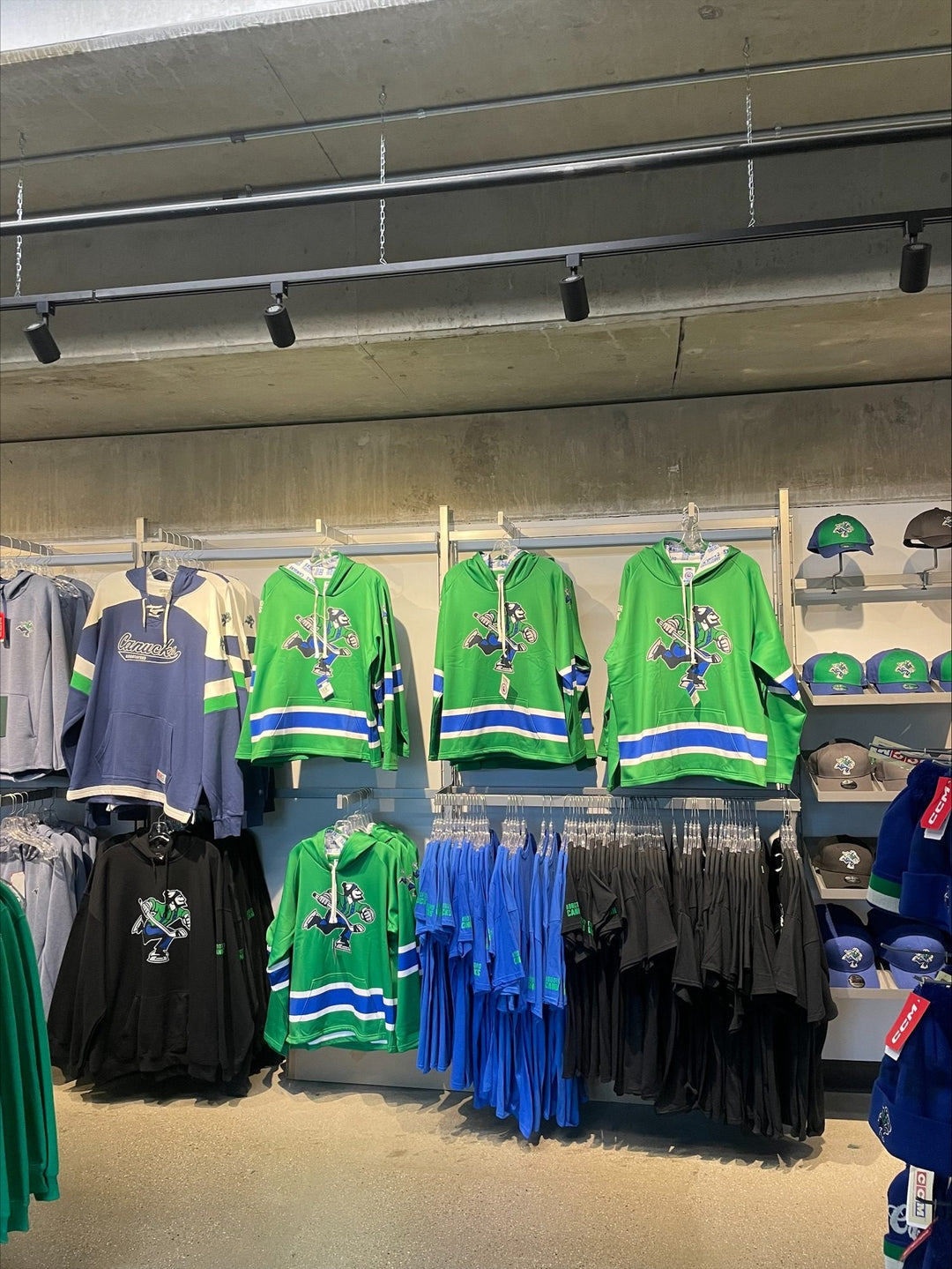 Bench Clearers Abbotsford Canucks green hockey hoodies on the wall of the Abbotsford Canucks team store
