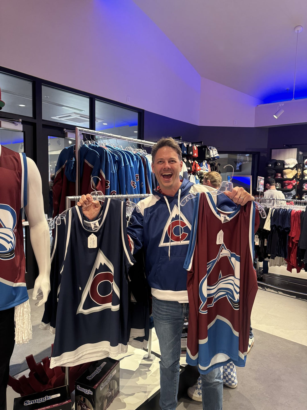 Holding up Bench Clearers Colorado Avalanche hockey tanks inside the Avalanche team store
