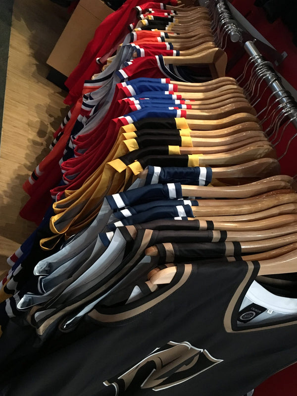 Close-up of Bench Clearers NHL hockey tanks hanging in the Hockey Hall of Fame store
