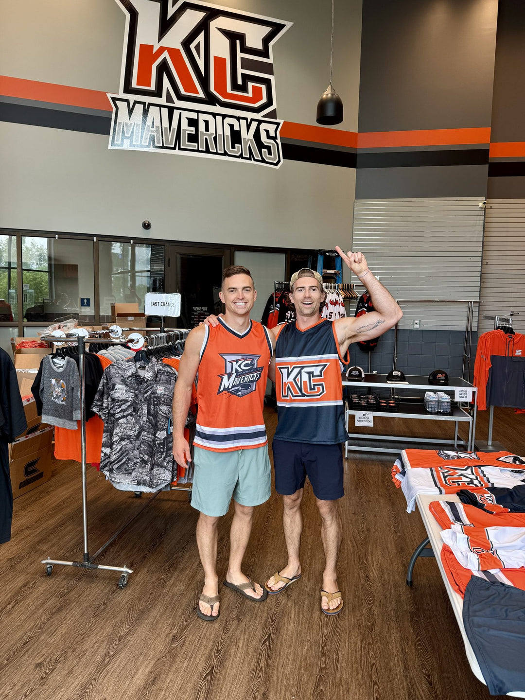 Two fans in Bench Clearers Kansas City Mavericks hockey tanks inside the Mavericks Top Shelf Team Store